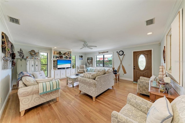 living area featuring baseboards, a ceiling fan, light wood-style flooring, and visible vents
