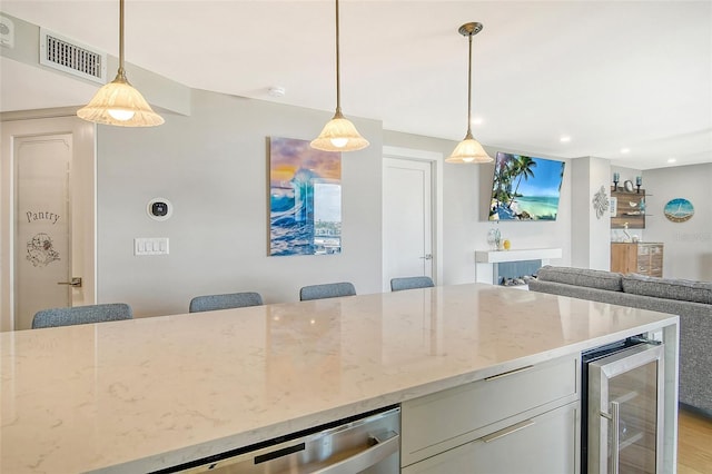 kitchen featuring visible vents, pendant lighting, light stone counters, recessed lighting, and wine cooler