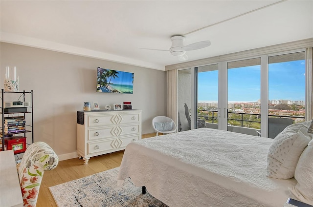 bedroom with access to exterior, light wood-style flooring, a ceiling fan, and baseboards