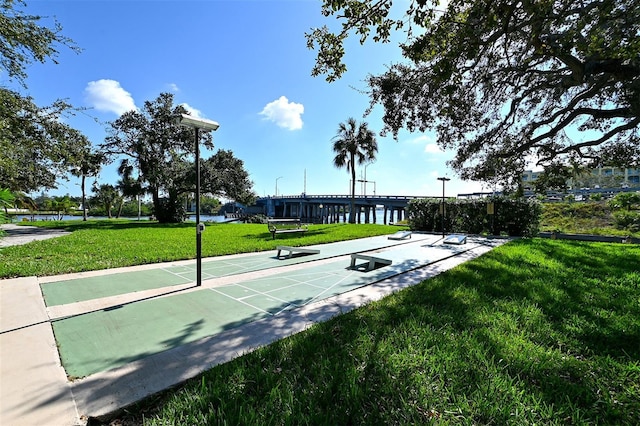 view of community featuring a lawn and shuffleboard