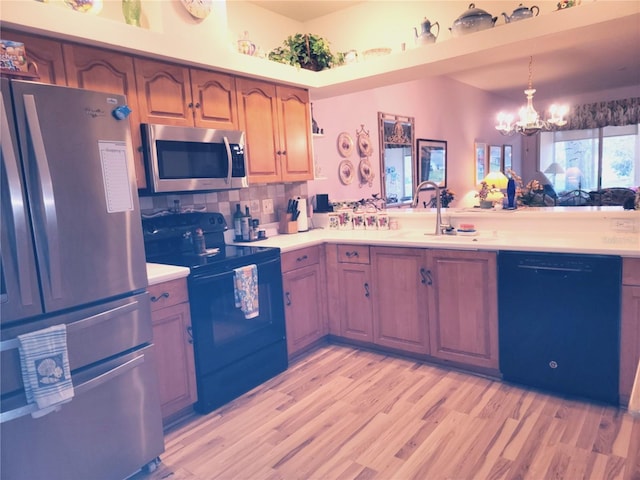 kitchen with stainless steel appliances, light hardwood / wood-style flooring, sink, a chandelier, and decorative backsplash