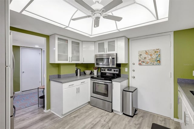 6415 Midnight Pass Rd Unit 211, Sarasota, FL 34242 - kitchen featuring stainless steel appliances, white cabinets, light wood-type flooring, and a ceiling fan