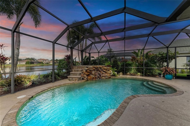 pool at dusk featuring a patio, glass enclosure, and a water view