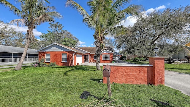 ranch-style house with a front yard, concrete driveway, fence, and an attached garage