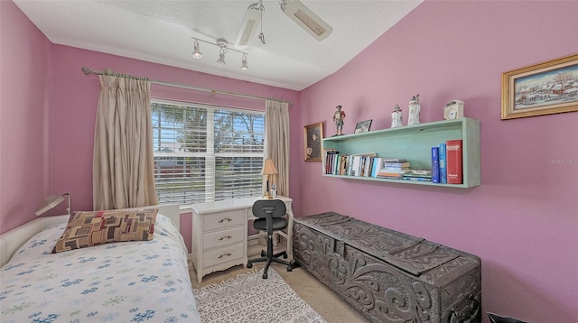 bedroom featuring carpet floors, rail lighting, a ceiling fan, and a textured ceiling