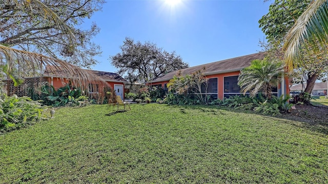 view of yard featuring an outbuilding and a sunroom