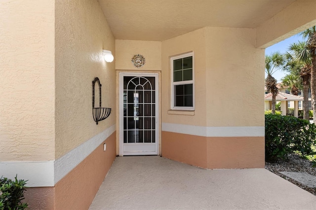 entrance to property featuring stucco siding