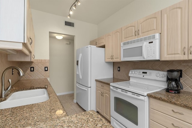 kitchen featuring light tile patterned floors, visible vents, light brown cabinets, a sink, and white appliances