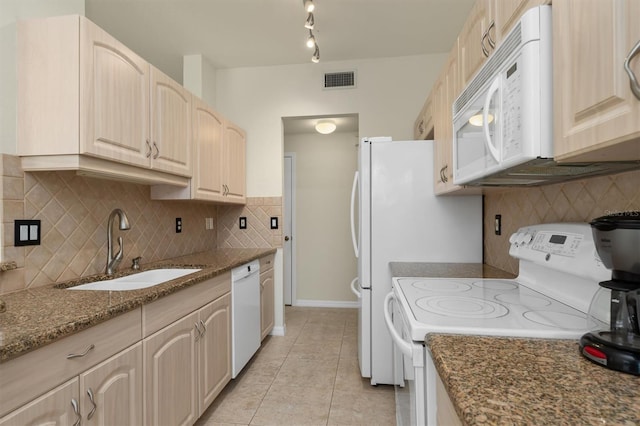 kitchen featuring light tile patterned floors, white appliances, a sink, visible vents, and light stone countertops