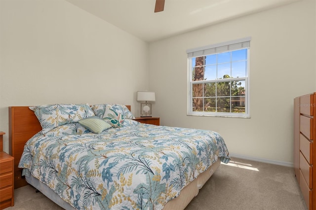 bedroom featuring a ceiling fan, light carpet, and baseboards