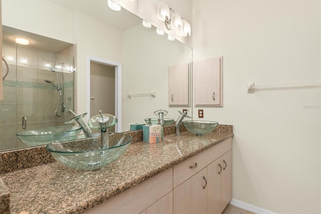 bathroom featuring double vanity, a shower stall, and a sink