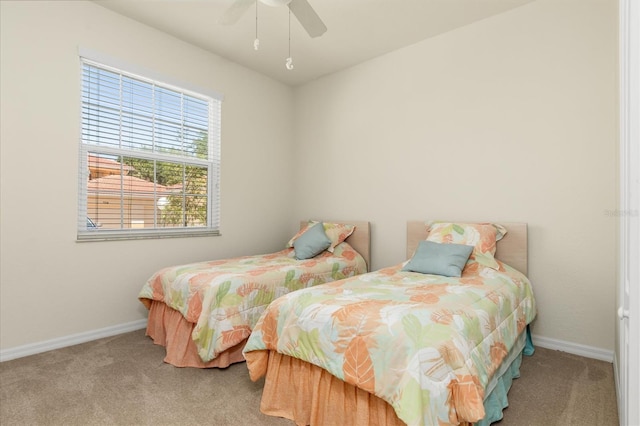 carpeted bedroom with ceiling fan and baseboards