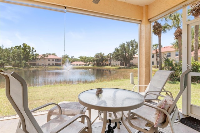 sunroom with a water view and a residential view