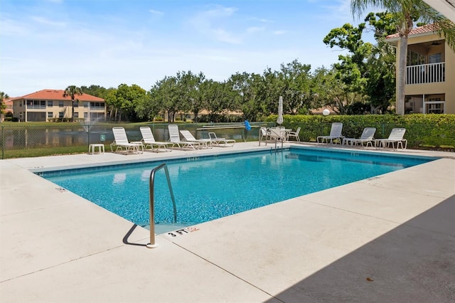 community pool with a patio area and fence