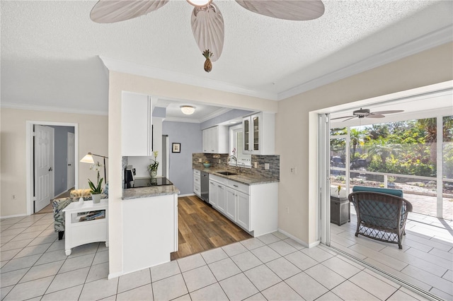 kitchen with white cabinetry, glass insert cabinets, a sink, and light tile patterned flooring