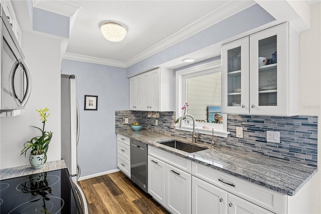 kitchen with white cabinets, glass insert cabinets, light stone countertops, stainless steel appliances, and a sink