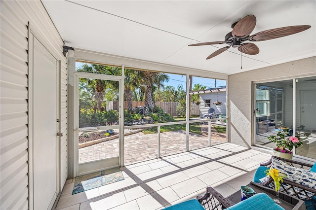 unfurnished sunroom featuring ceiling fan