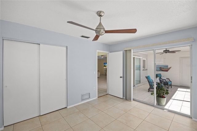 unfurnished bedroom featuring light tile patterned floors, a closet, visible vents, and a textured ceiling