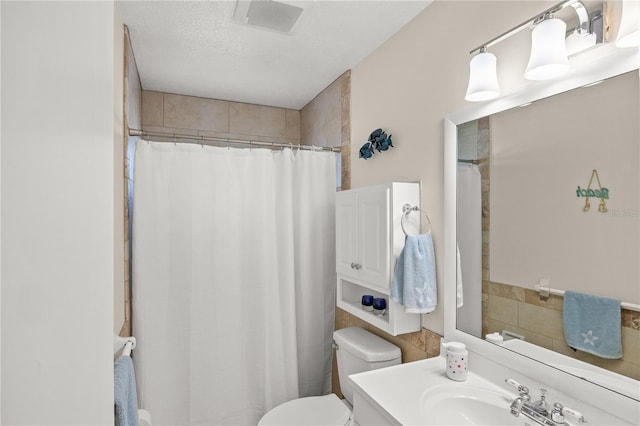 bathroom featuring a textured ceiling, toilet, visible vents, vanity, and a shower with curtain