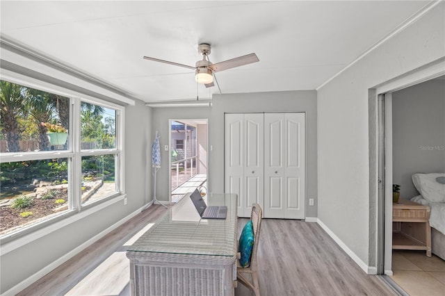 home office with a ceiling fan, light wood-style flooring, and baseboards