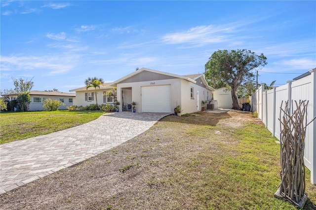 ranch-style house with an attached garage, fence, decorative driveway, and a front yard