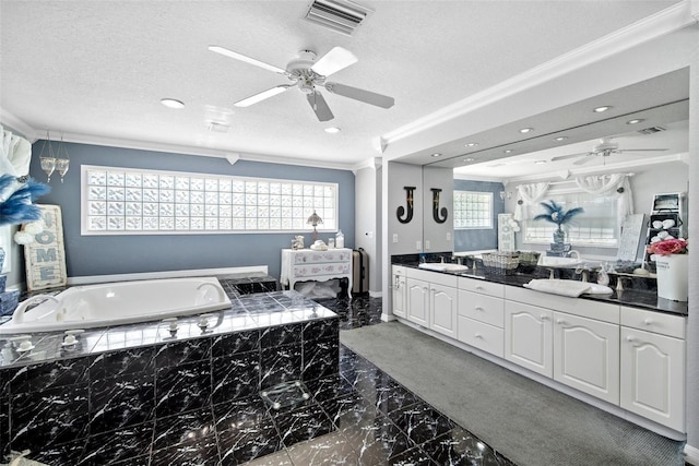 bathroom with a wealth of natural light, ornamental molding, tiled bath, and a textured ceiling