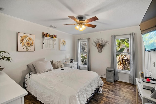 bedroom with ornamental molding, dark hardwood / wood-style floors, a textured ceiling, and ceiling fan