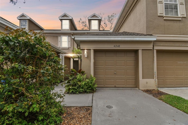 exterior space with concrete driveway and stucco siding