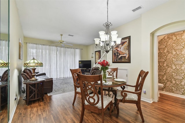 dining room featuring baseboards, visible vents, dark wood-style flooring, and ceiling fan with notable chandelier