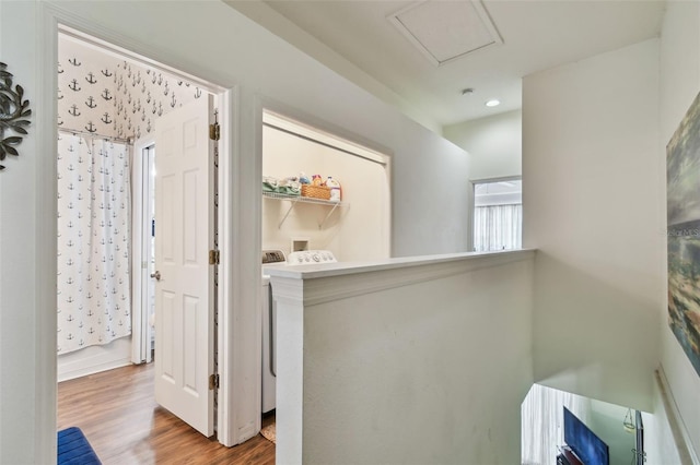 corridor featuring wood finished floors and an upstairs landing