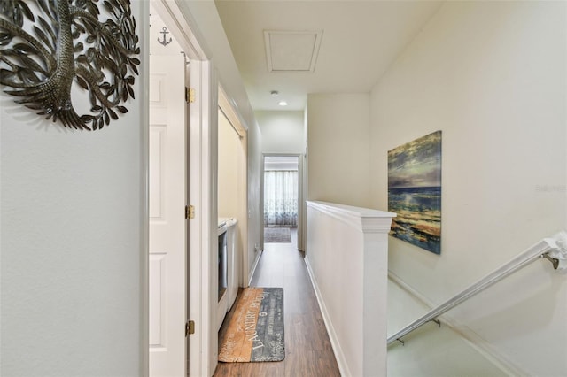 hall with baseboards, an upstairs landing, and wood finished floors