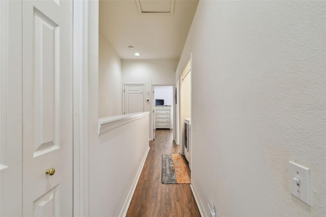 hall with dark wood-style floors and baseboards