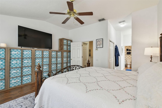 bedroom featuring connected bathroom, visible vents, vaulted ceiling, and wood finished floors