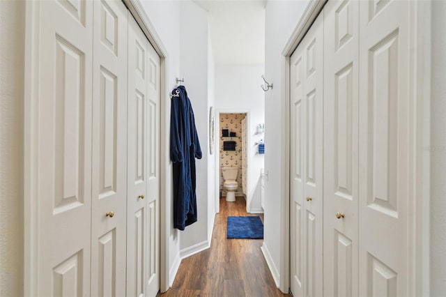 corridor with baseboards and dark wood finished floors