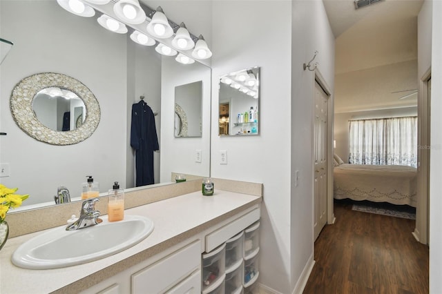 bathroom featuring baseboards, visible vents, wood finished floors, ensuite bathroom, and vanity