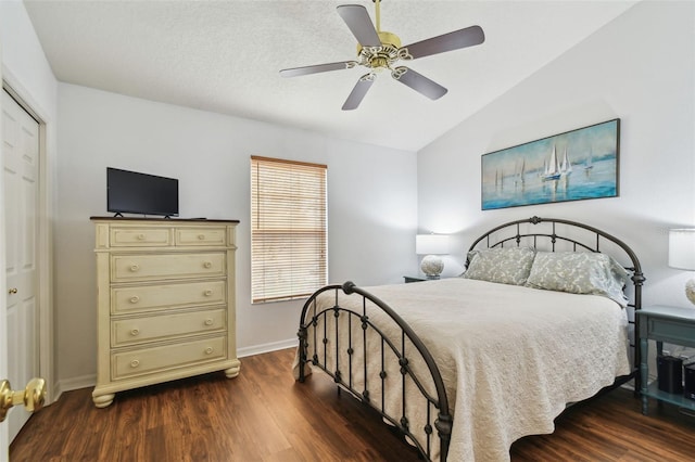 bedroom featuring vaulted ceiling, ceiling fan, dark wood-style flooring, and baseboards