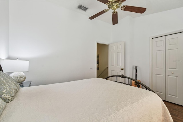 bedroom featuring ceiling fan, a closet, visible vents, and dark wood-style flooring