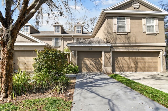 view of front facade featuring a garage, concrete driveway, and stucco siding