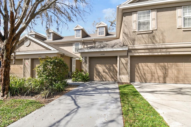 view of front of property featuring driveway, a garage, and stucco siding