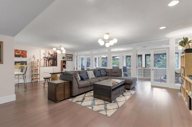 living area with french doors, an inviting chandelier, and wood finished floors