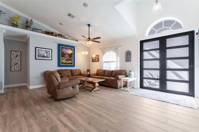 living room with vaulted ceiling, ornamental molding, ceiling fan, and light hardwood / wood-style flooring