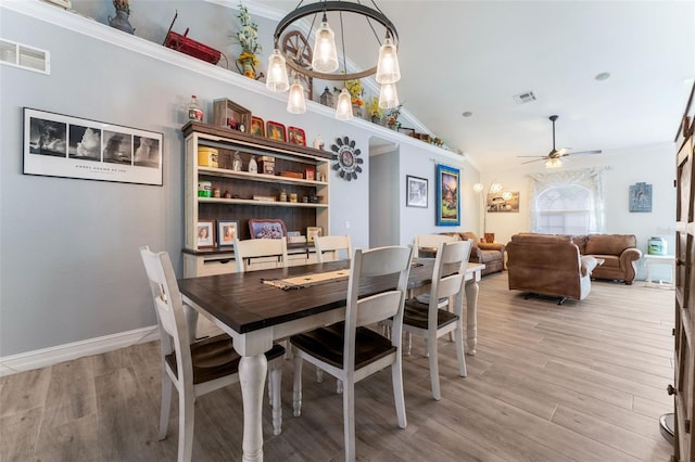 dining area with lofted ceiling, ceiling fan with notable chandelier, light hardwood / wood-style flooring, and ornamental molding