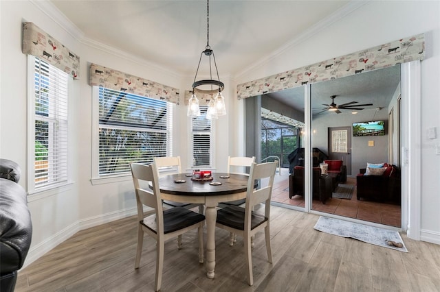 dining space with crown molding, hardwood / wood-style flooring, and plenty of natural light