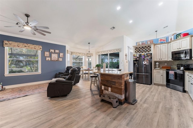 kitchen featuring range with electric cooktop, a kitchen island, decorative light fixtures, lofted ceiling, and black fridge