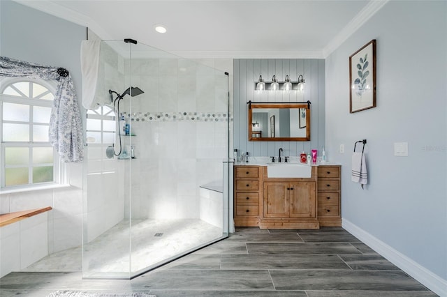 bathroom with ornamental molding, vanity, and a tile shower