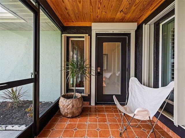 unfurnished sunroom featuring wood ceiling and a wealth of natural light