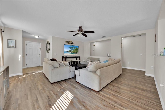 living room featuring light hardwood / wood-style floors and ceiling fan