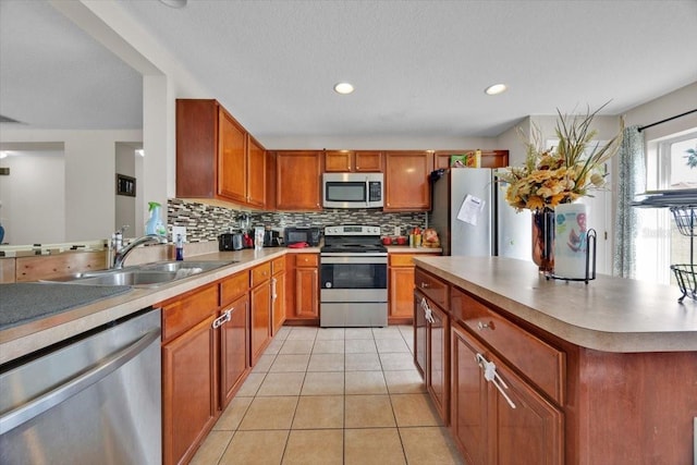 kitchen with appliances with stainless steel finishes, sink, backsplash, and light tile patterned floors