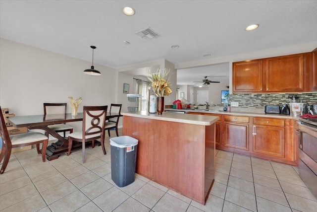 kitchen with hanging light fixtures, a kitchen island, backsplash, stainless steel electric stove, and light tile patterned flooring