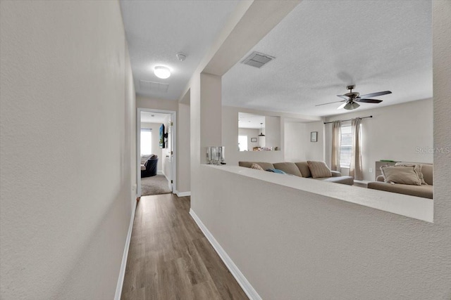 hallway featuring a textured ceiling and hardwood / wood-style floors